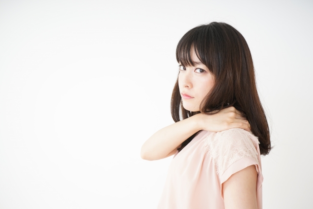 女性が首を手で押さえ、痛みを感じている様子の画像