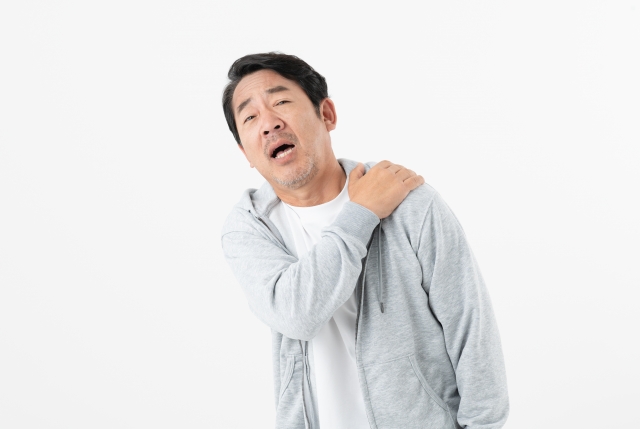 中年男性が肩の痛みを訴えている様子